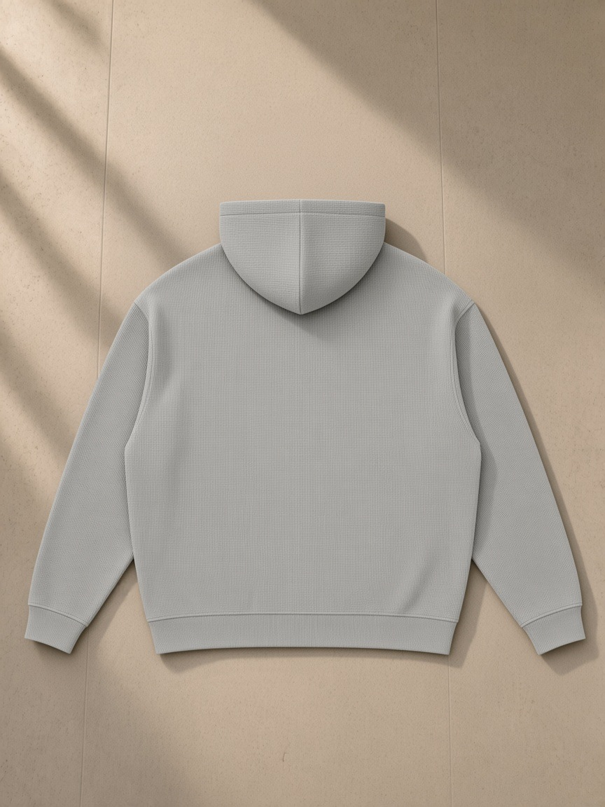 Waffle Hoodie in Light Gray, laid flat on pale limestone, back view