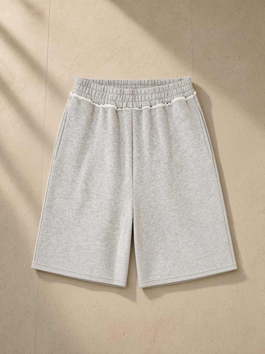 Raw edge fleece shorts in Flower Gray, laid flat on pale limestone