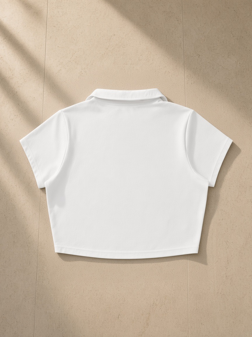 V-Neck Lapel Crop Top in White, laid flat on pale limestone, back view