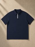 Quarter-Zip Knit Polo in Navy Blue, laid flat on pale limestone