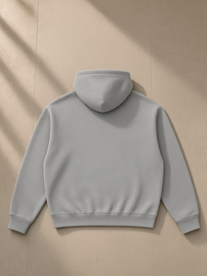Unisex heavyweight fleece boxy hoodie in Flower Gray, laid flat on pale limestone, back view