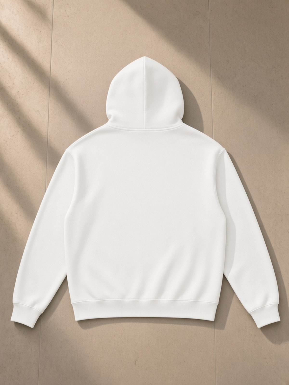 Essential Heavyweight Drop-Shoulder Hoodie in White, laid flat on pale limestone, back.