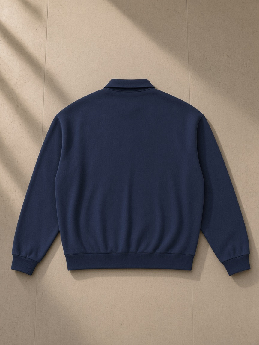 Heavyweight fleece polo sweatshirt in Navy Blue, laid flat on pale limestone, back view