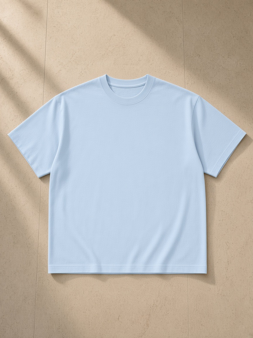 Unisex cotton boxy t-shirt in Sky Blue, laid flat on pale limestone