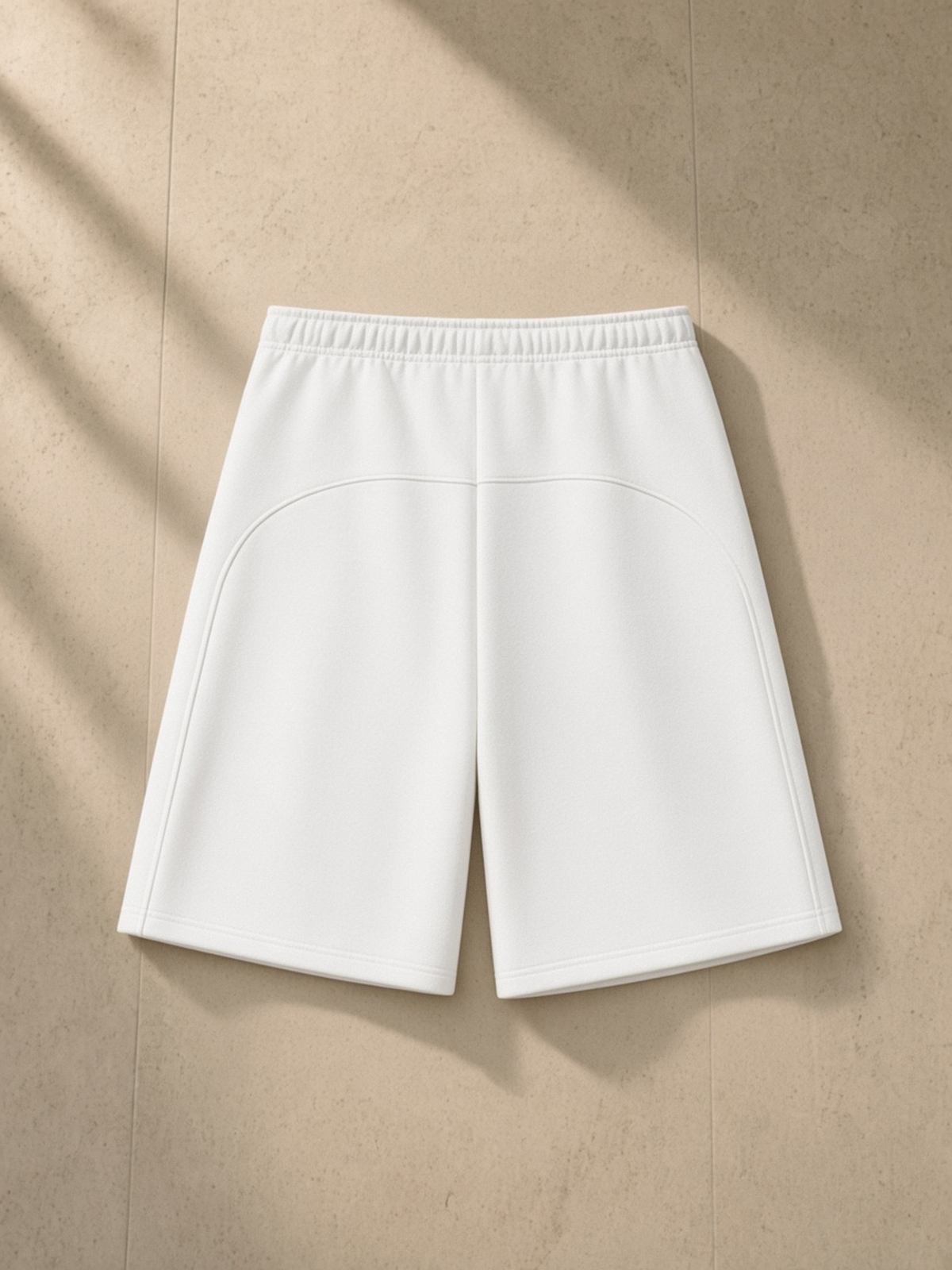 Essential Heavyweight Fleece Shorts in White, laid flat on pale limestone, back.