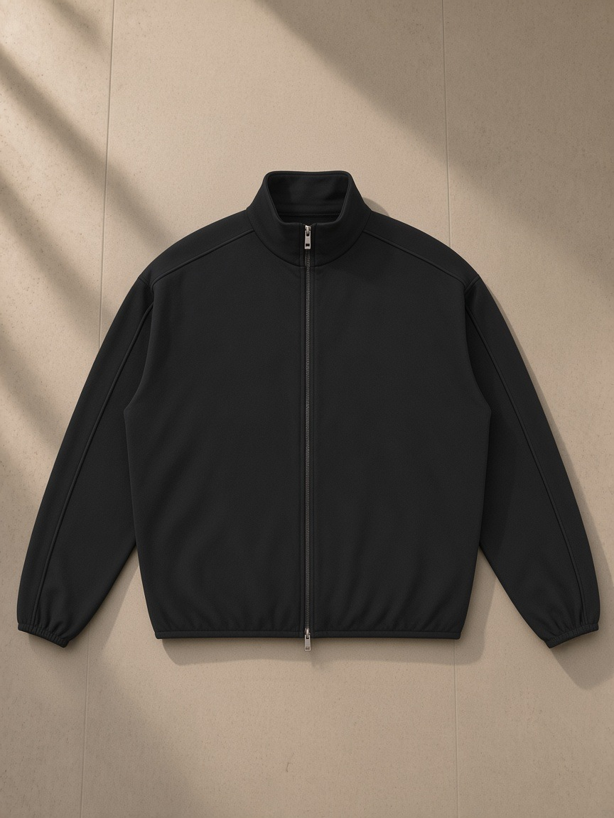 Heavyweight Stand Collar Jacket in Black, laid flat on pale limestone