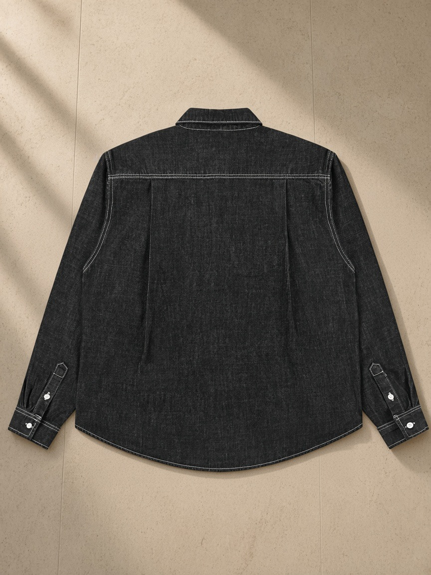 Vintage Wash Denim Shirt in Black, laid flat on pale limestone, back view