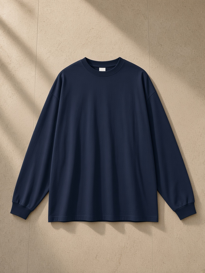 Oversized Long Sleeve T-Shirt in Navy, laid flat on pale limestone