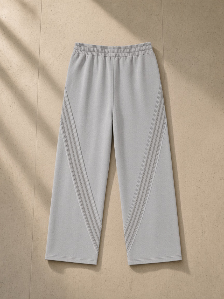 Snow Washed Tape Raw Edge Sweatpants in Light Gray, laid flat on pale limestone, back view