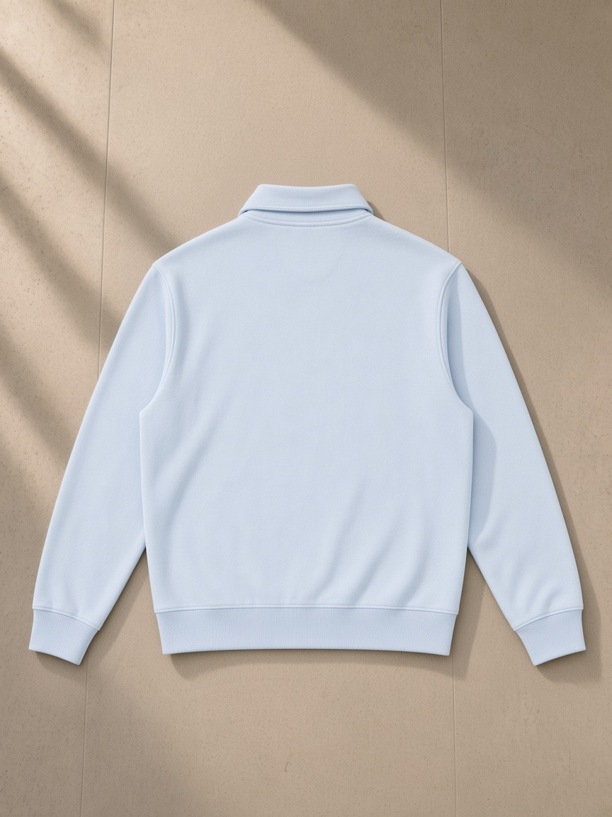Vintage wash quarter-zip sweatshirt in Light Blue, laid flat on pale limestone, back view