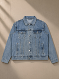 Vintage Wash Denim Jacket in Blue, laid flat on pale limestone
