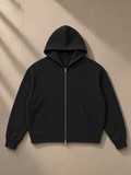 Unisex waffle boxy full zip hoodie in Black, laid flat on pale limestone