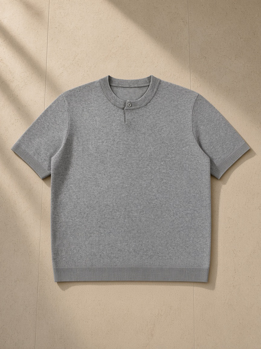 Unisex cotton knit short sleeve henley t-shirt in Flower Gray, laid flat on pale limestone