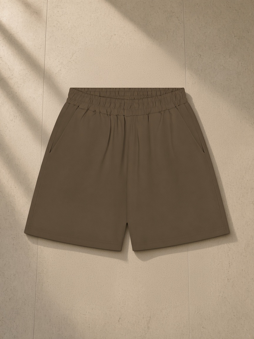 Unisex regular fit shorts in Coffee, laid flat on pale limestone