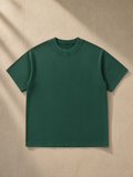 Mineral Wash Waffle Knit T-Shirt in Blackish Green, laid flat on pale limestone