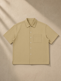 Boxy patch pocket short sleeve shirt in Khaki, laid flat on pale limestone