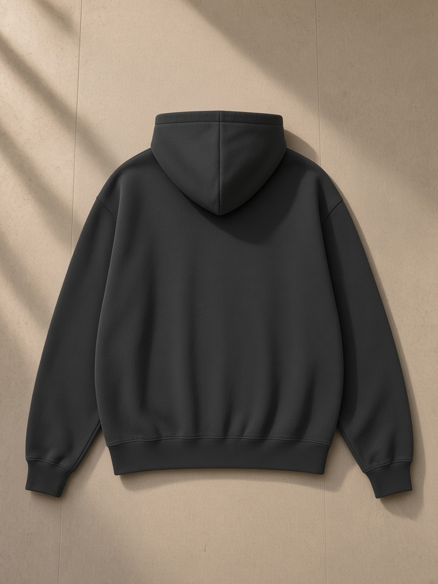 Unisex oversized heavyweight hoodie in Dark Gray on a wooden hanger on a wardrobe door in a Carlyle-style hotel suite at night
