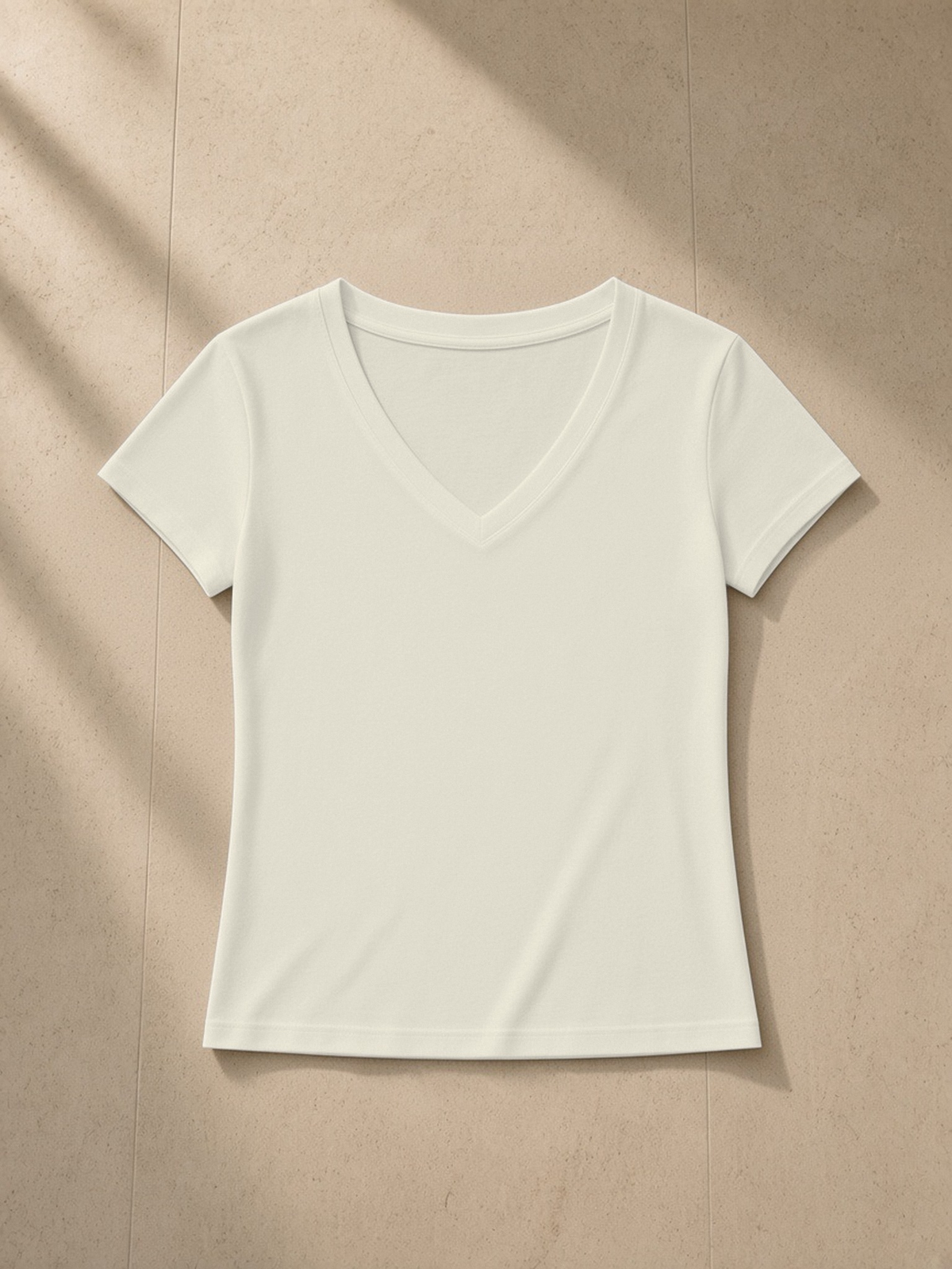 Tencel Slim Fit V-Neck T-Shirt in Light Apricot, laid flat on pale limestone, front.