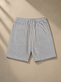 Essential Cotton Shorts in Flower Gray, laid flat on pale limestone