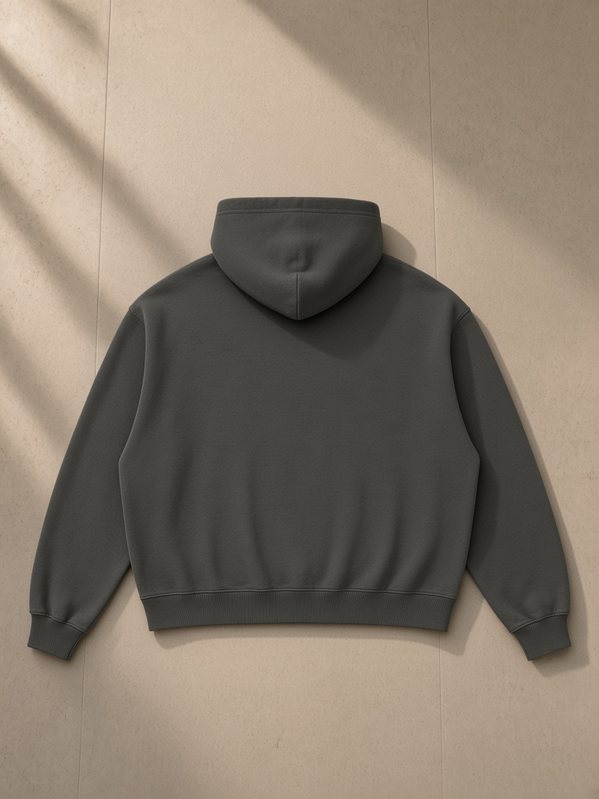 Boxy vintage washed hoodie in Dark Gray, laid flat on pale limestone, back view
