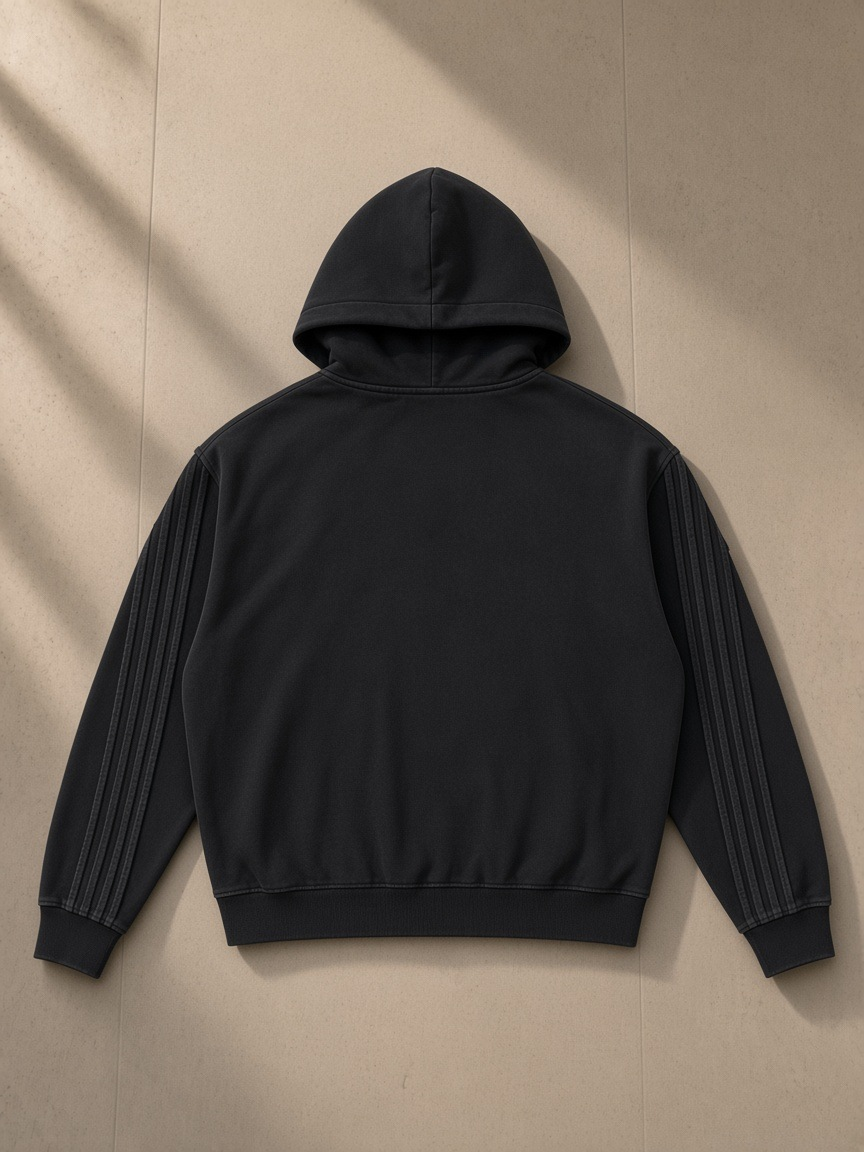 Unisex snow washed tape raw edge zip hoodie in Black, laid flat on pale limestone, back view