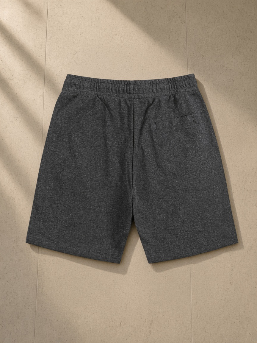 Essential Cotton Shorts in Dark Gray, laid flat on pale limestone, back view