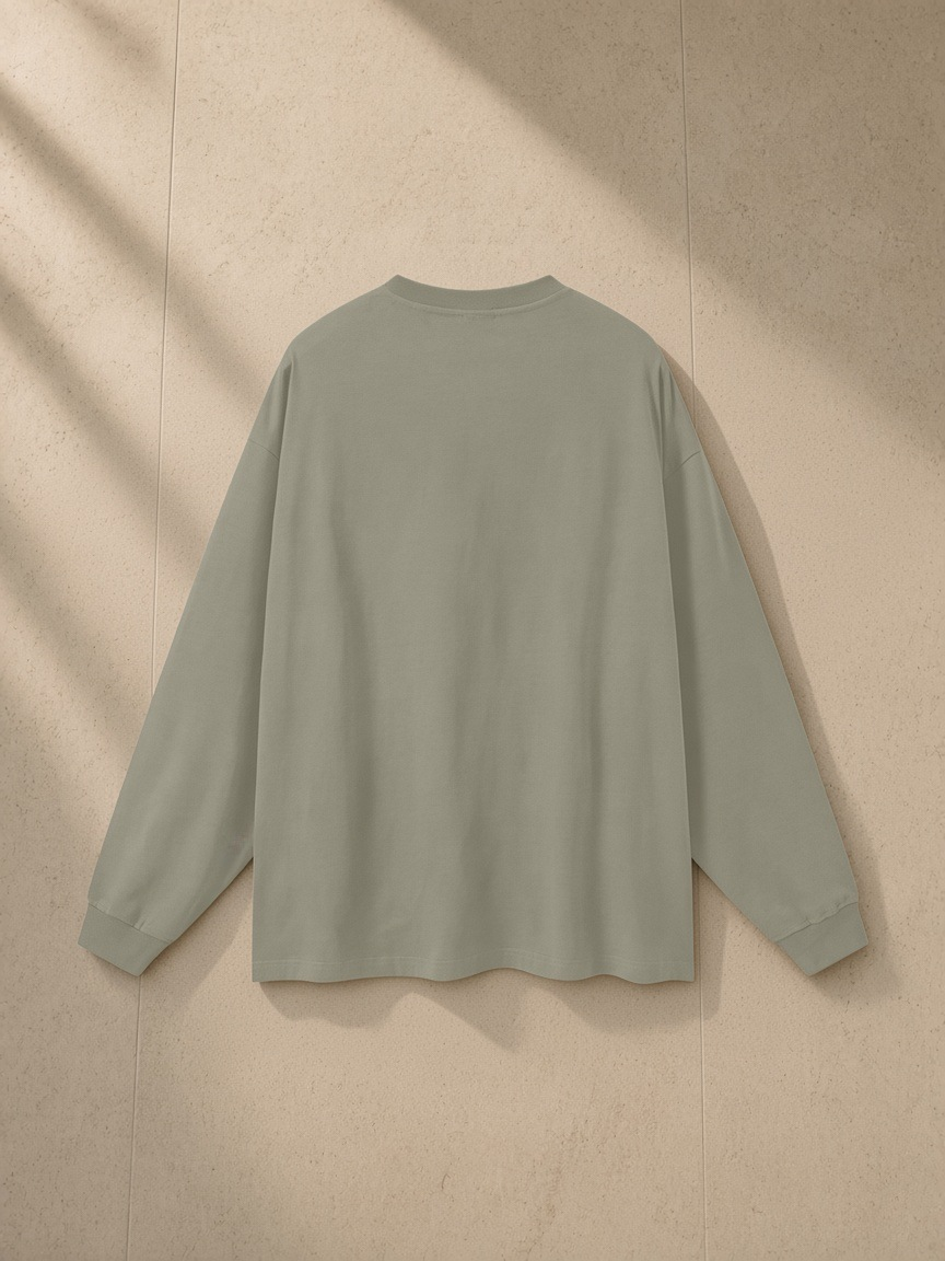 Oversized Long Sleeve T-Shirt in Gray Green, laid flat on pale limestone, back view
