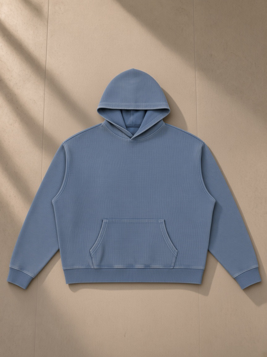 Vintage Wash Waffle Boxy Hoodie in Jeans Blue, laid flat on pale limestone, front.
