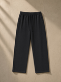 Mineral wash waffle sweatpants in Black, laid flat on pale limestone