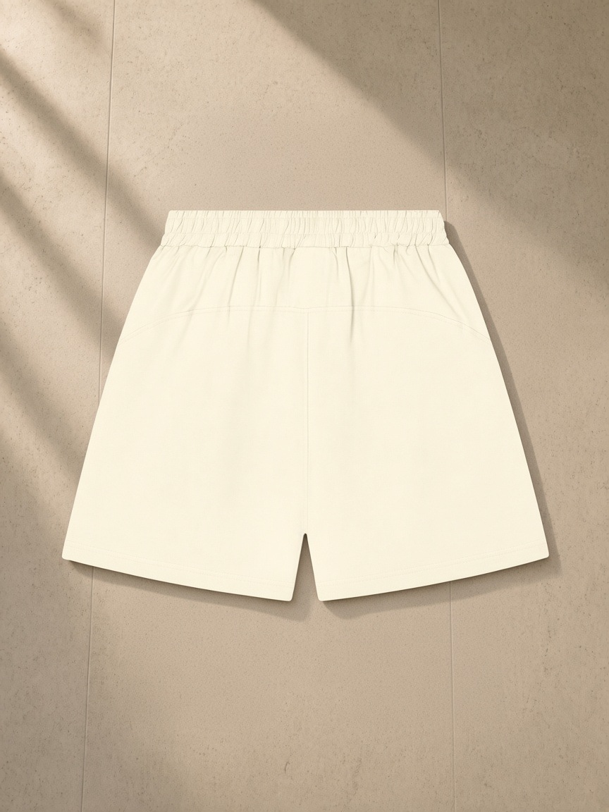 Unisex regular fit shorts in Apricot, laid flat on pale limestone, back view