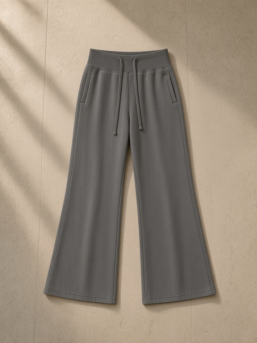 Vintage washed flared fleece pants in Dark Gray, laid flat on pale limestone
