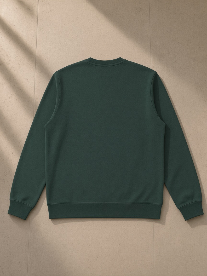 Unisex heavyweight crewneck sweatshirt in Retro Green, laid flat on pale limestone, back view
