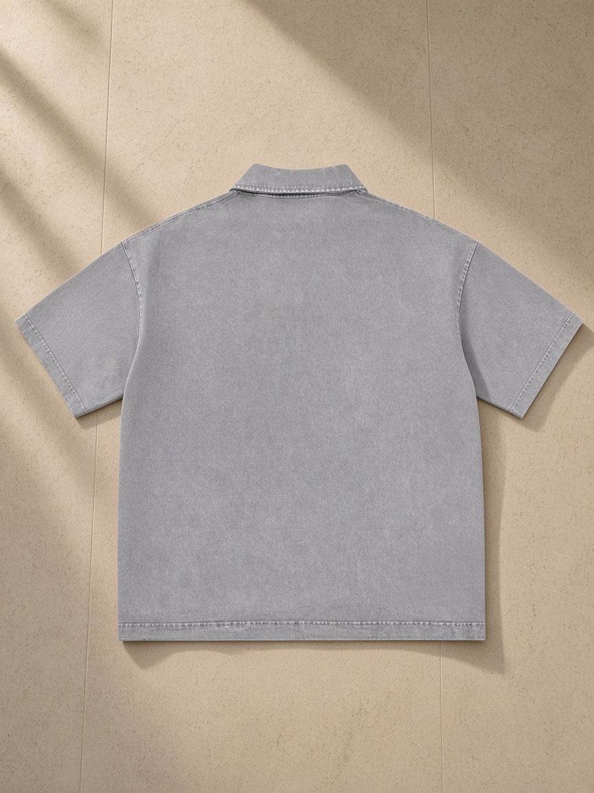 Heavyweight Snow-Washed Polo in Light Gray, laid flat on pale limestone, back view