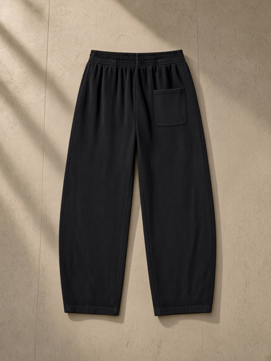 Vintage Washed Barrel Leg Sweatpants in Black, laid flat on pale limestone, back.