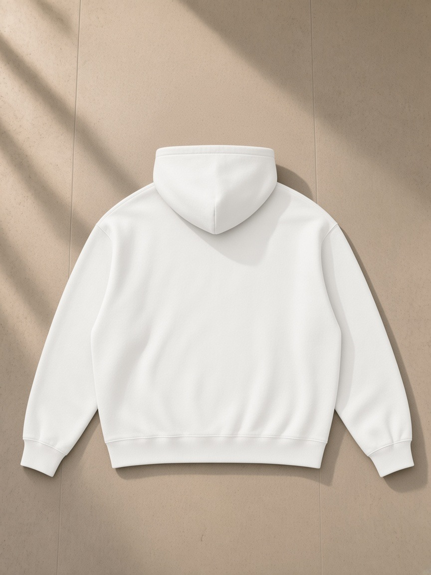 Oversize fleeced hoodie in White, laid flat on pale limestone, back view