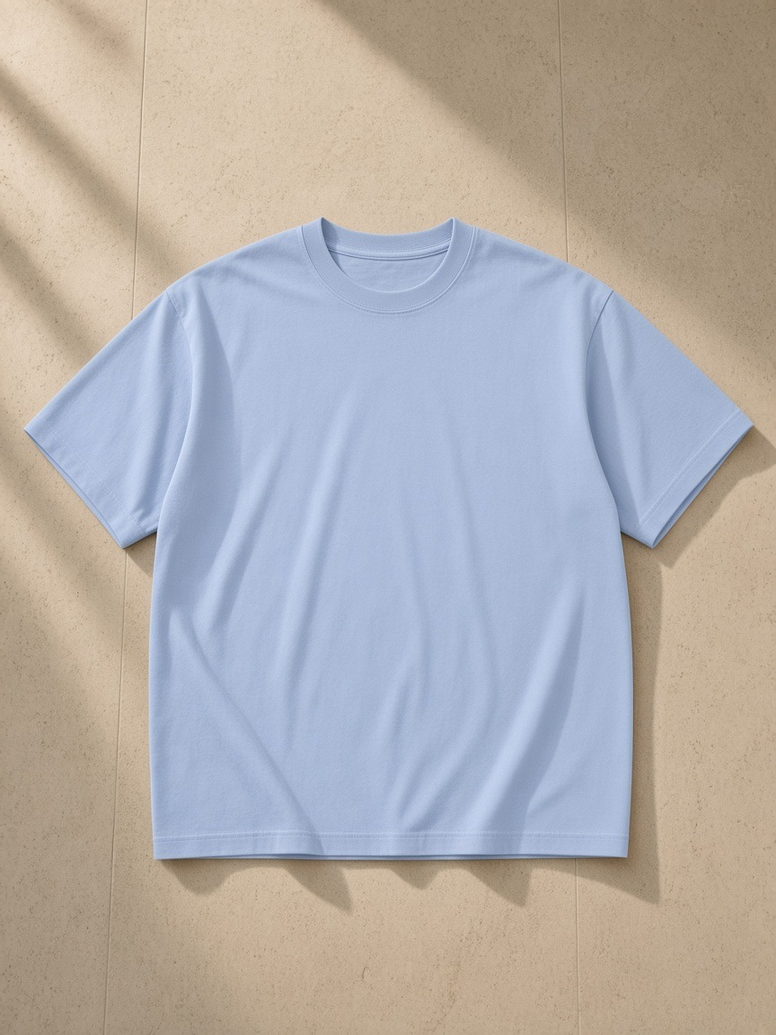Unisex pure cotton t-shirt in Sky Blue, laid flat on pale limestone
