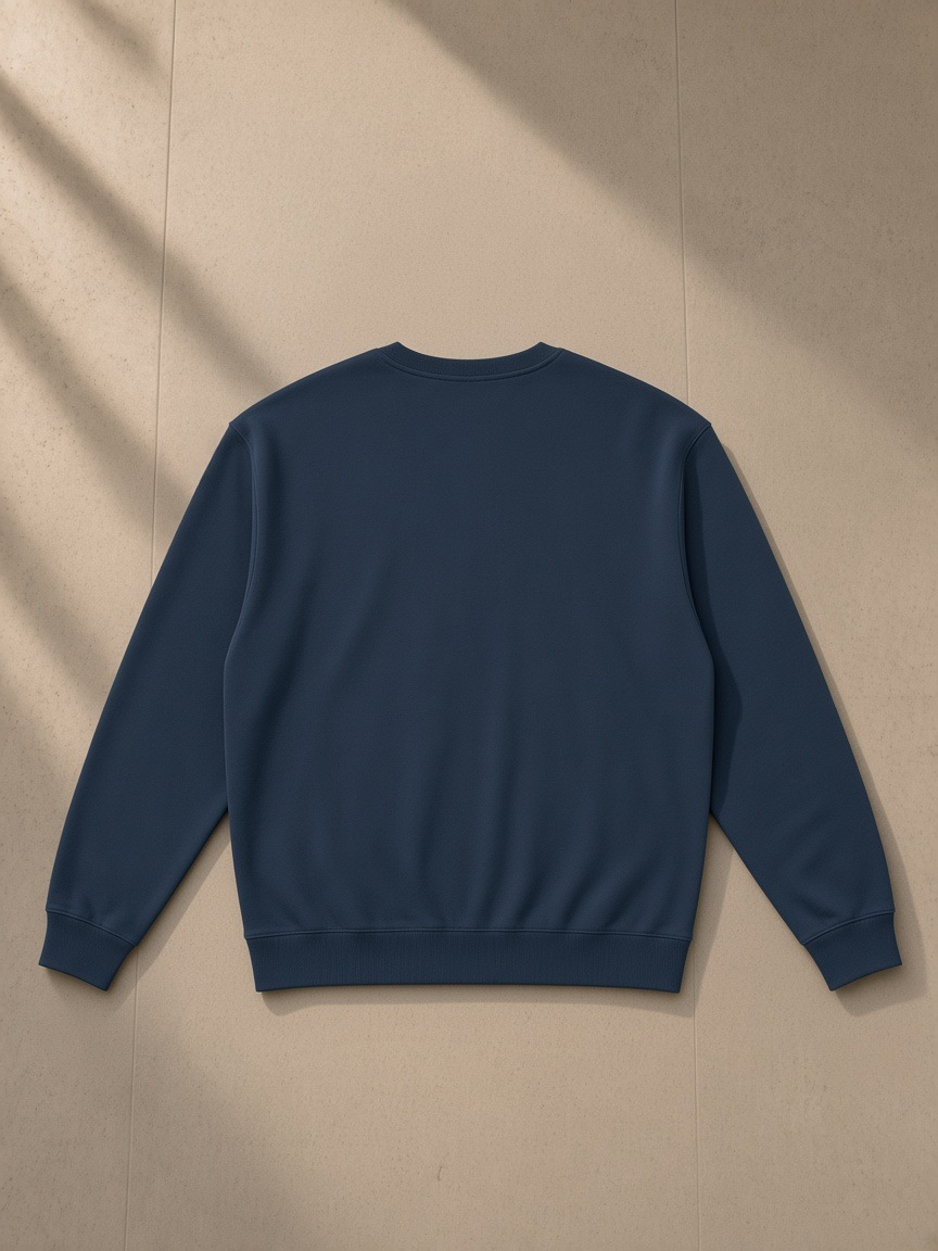 Loose Crewneck Sweatshirt in Navy Blue, laid flat on pale limestone, back view