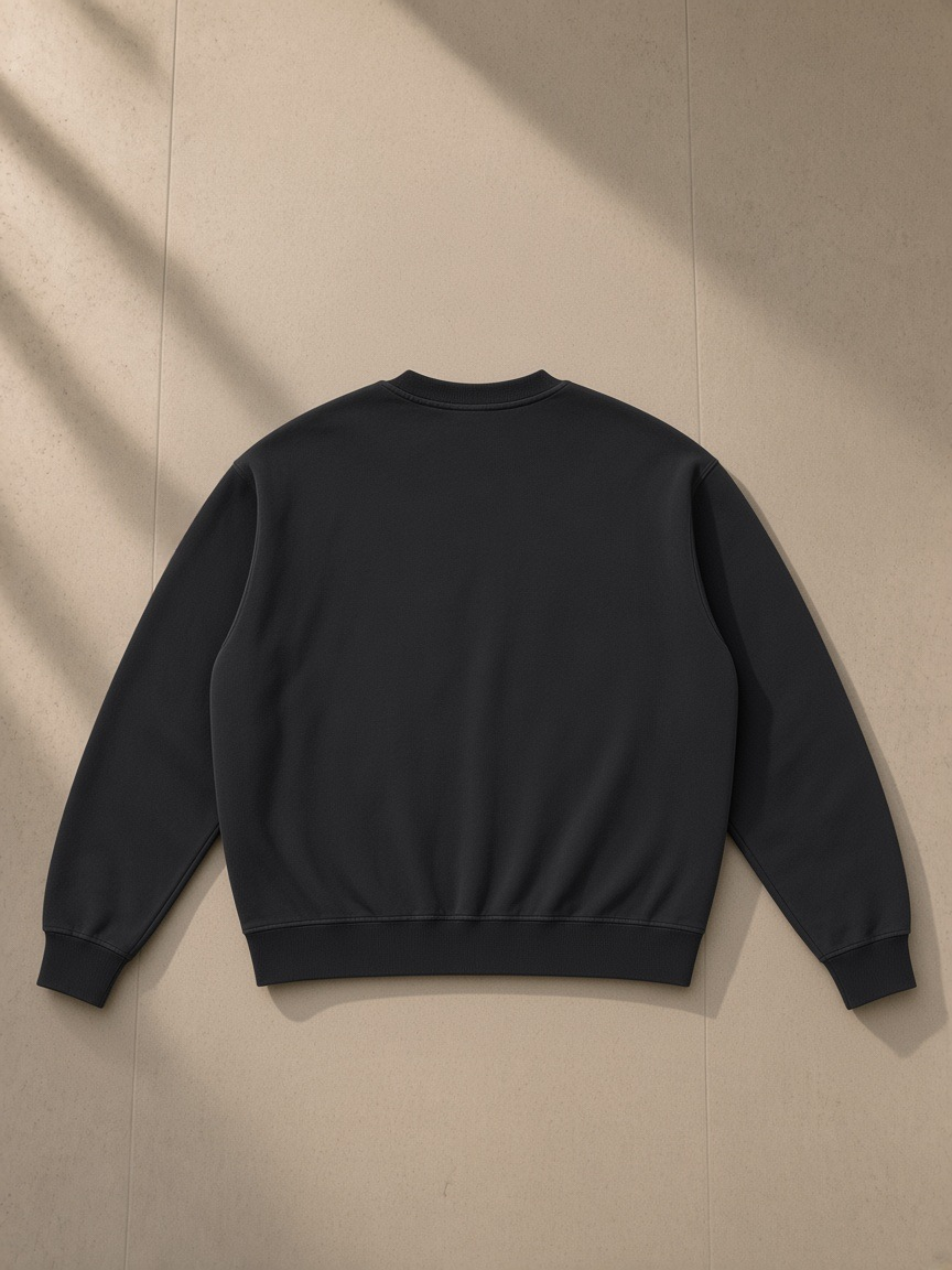 Boxy Vintage Washed Sweatshirt in Black, laid flat on pale limestone, back view