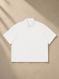 Boxy Short Sleeve Shirt in White, laid flat on pale limestone
