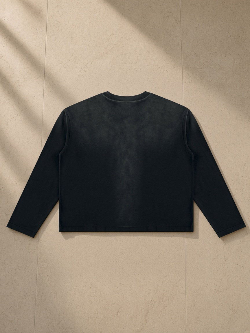 Sunfade Boxy Long Sleeve T-Shirt in Black, laid flat on pale limestone, back.