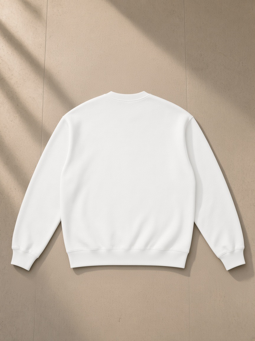 Oversized drop shoulder crewneck sweatshirt in White, laid flat on pale limestone, back view