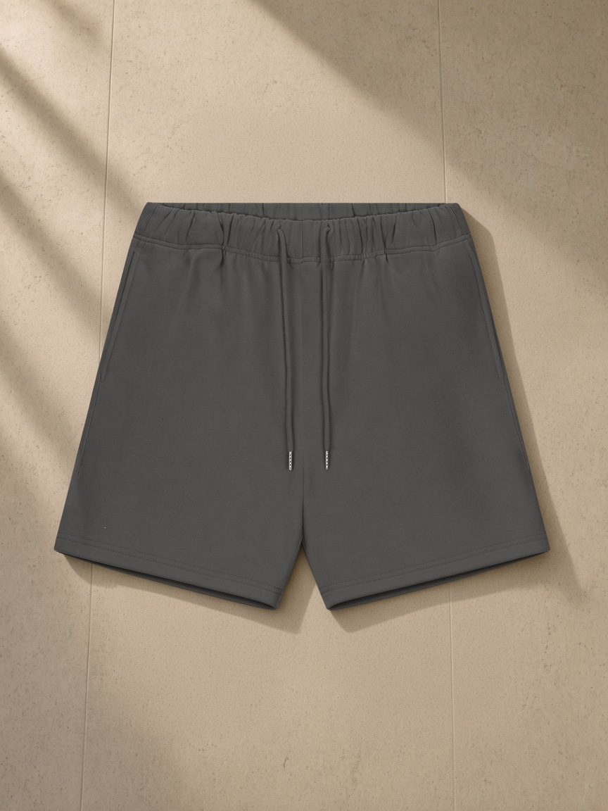 Heavyweight fleece loose fit shorts in Charcoal, laid flat on pale limestone