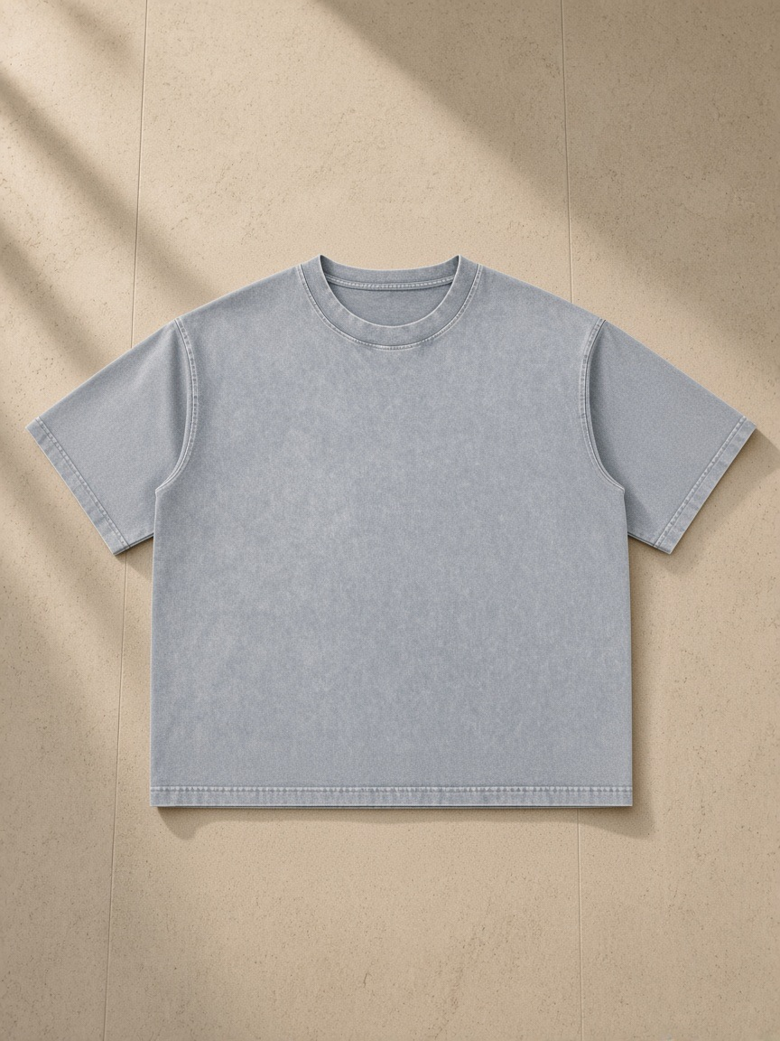 Unisex mineral wash boxy cotton t-shirt in Light Gray, laid flat on pale limestone
