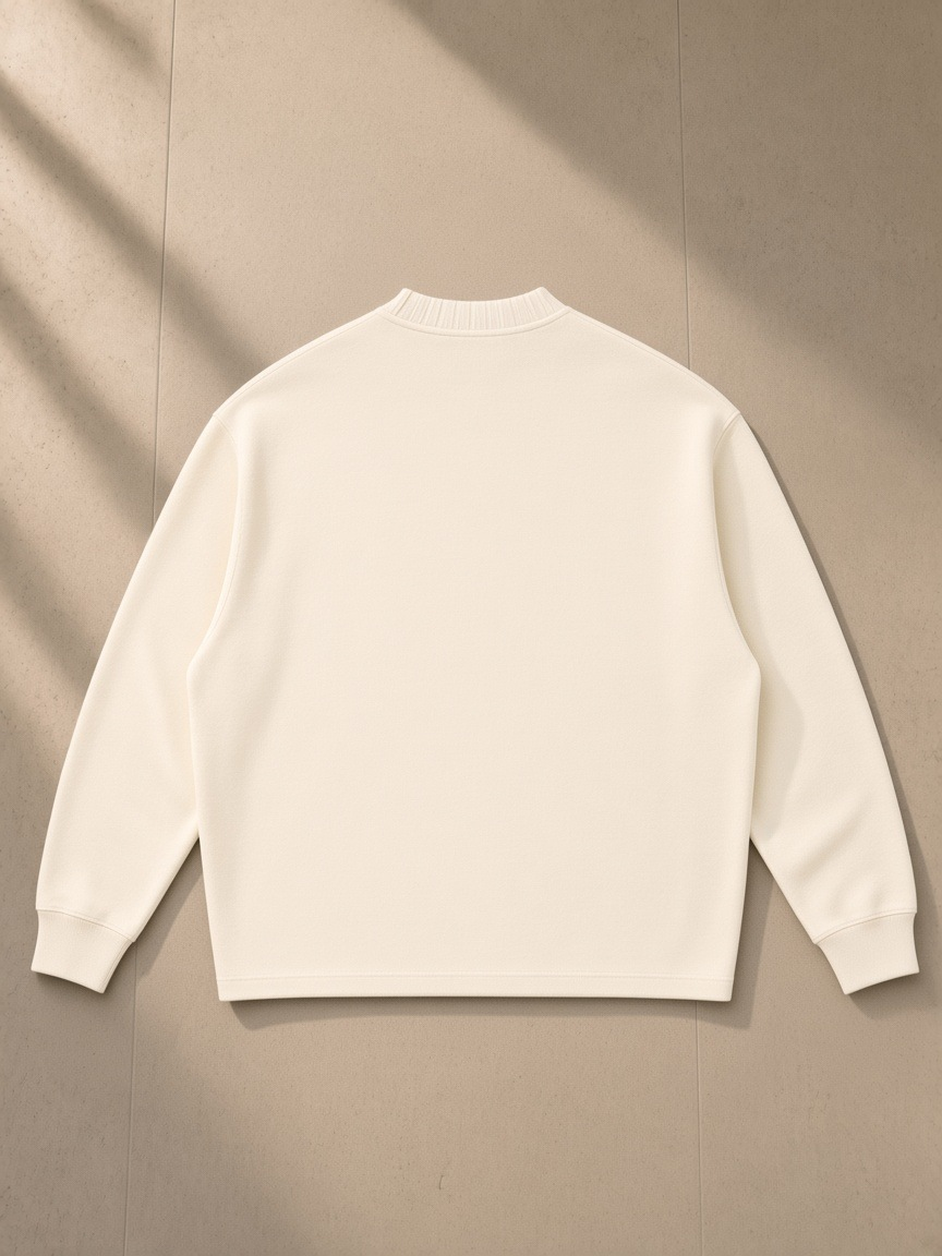 Unisex knitted round neck oversize sweatshirt in Apricot, laid flat on pale limestone, back view