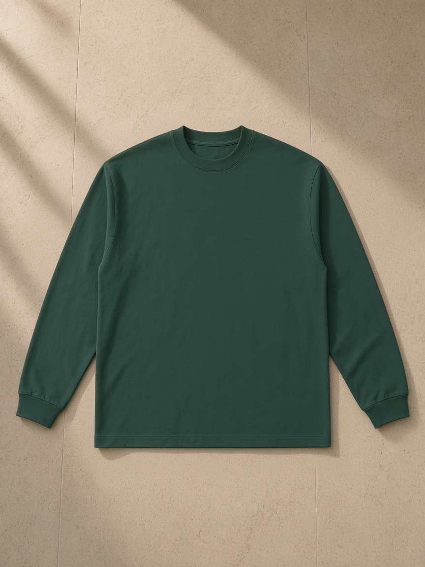 Essential Cotton Long Sleeve T-Shirt in Green, laid flat on pale limestone
