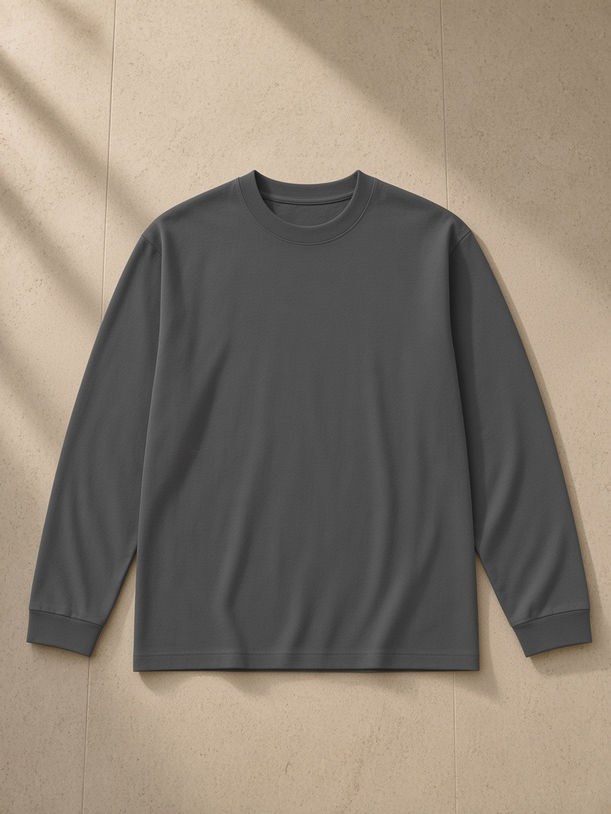 Crew neck drop shoulder long sleeve shirt in Dark Gray, laid flat on pale limestone