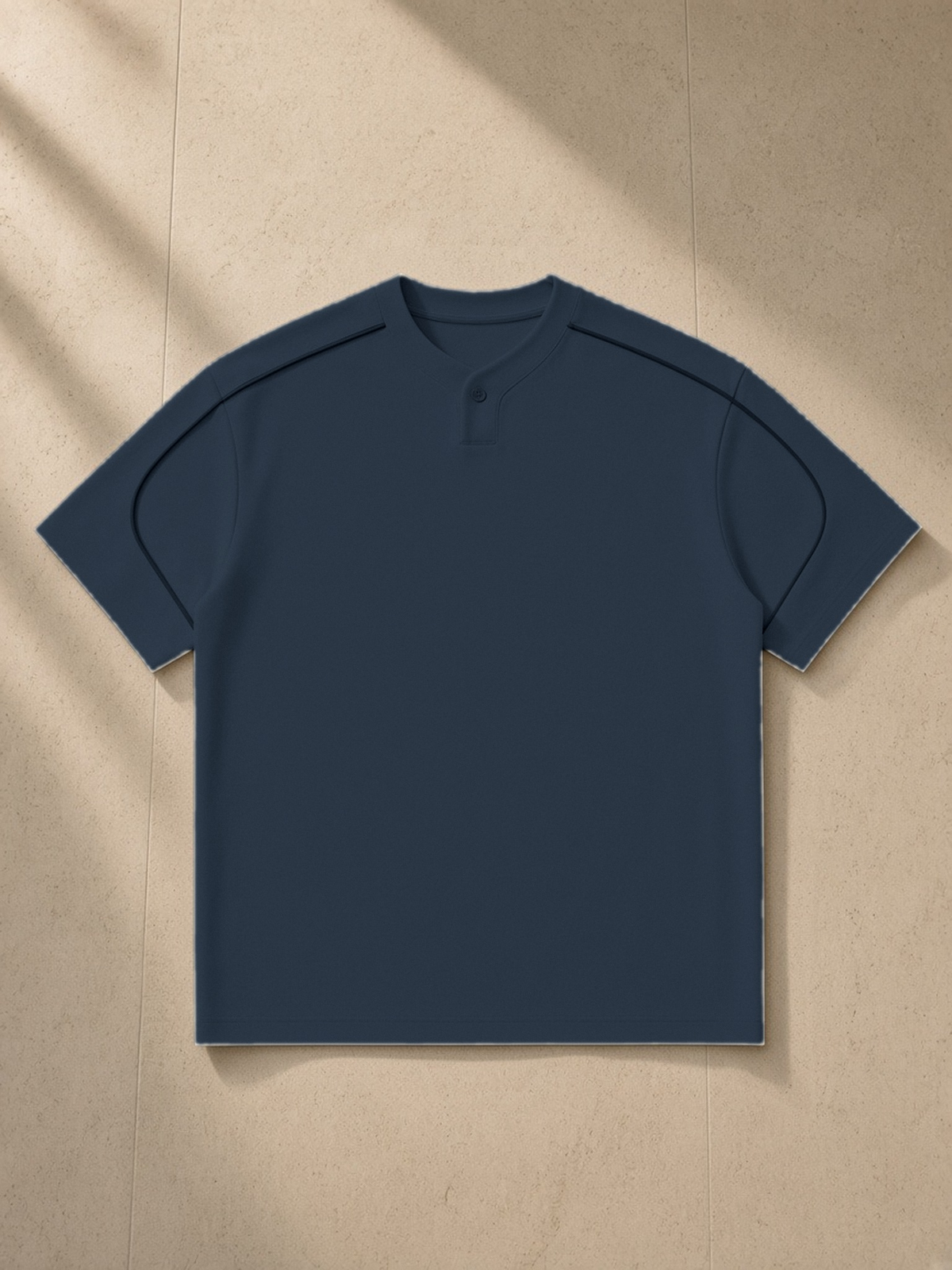 Oversized Piping Henley T-Shirt in Navy Blue, laid flat on pale limestone, front.