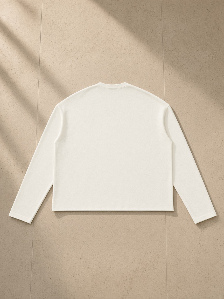 Raw Edge Long Sleeve T-Shirt in White, laid flat on pale limestone, back view