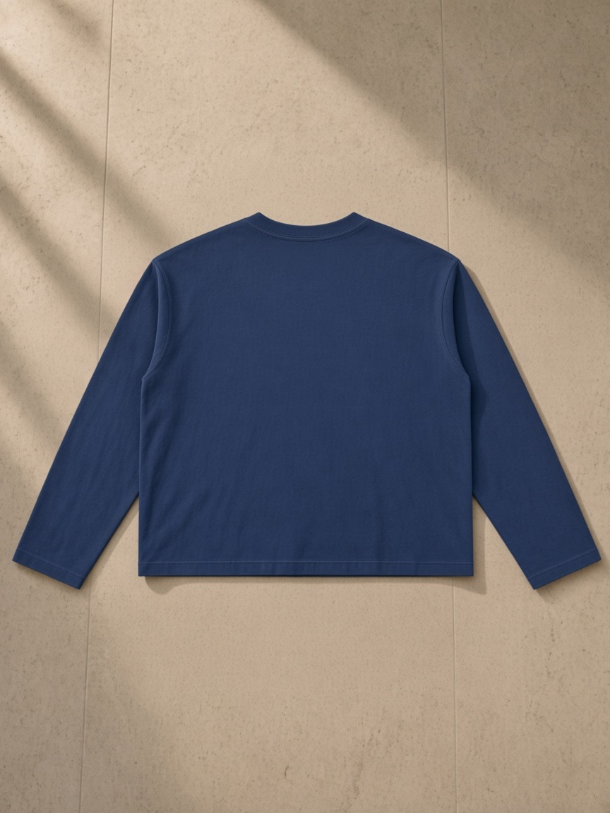 Vintage Wash Long Sleeve Boxy T-Shirt in Navy Blue, laid flat on pale limestone, back.