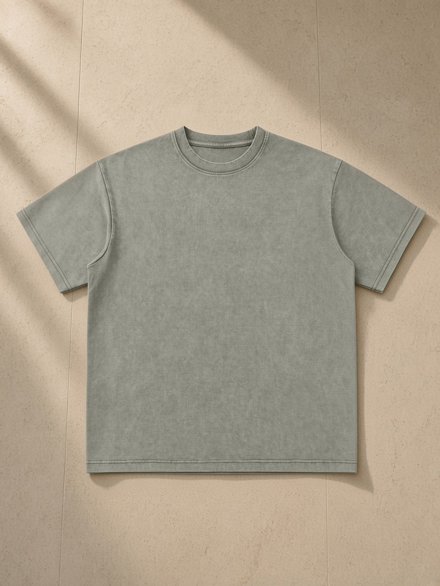 Unisex bamboo slub snow washed t-shirt in Bean Green, laid flat on pale limestone